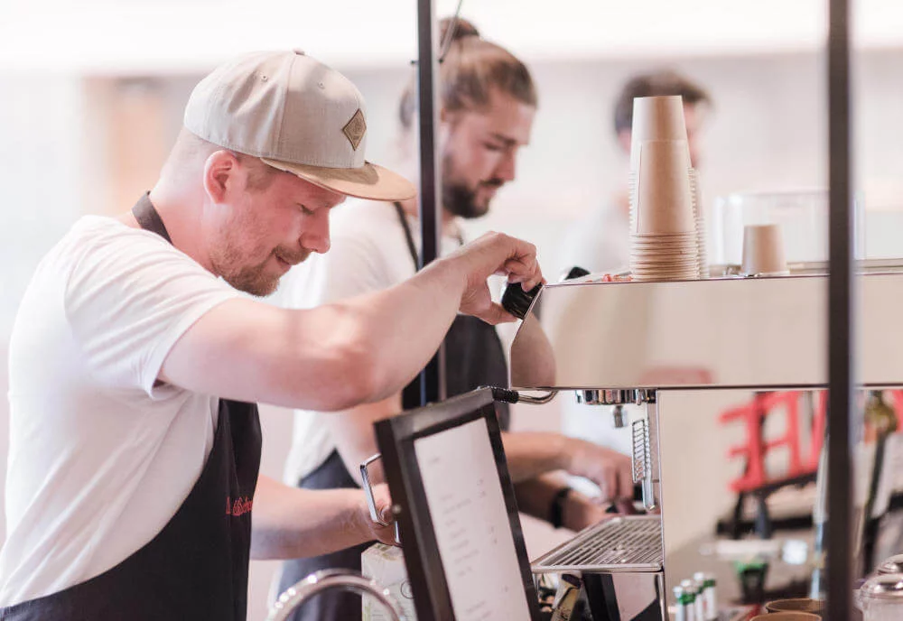 Barister in einem Kaffeestand von STREET-KITCHEN bei der Kaffee zubereitet bei einem Catering-Event