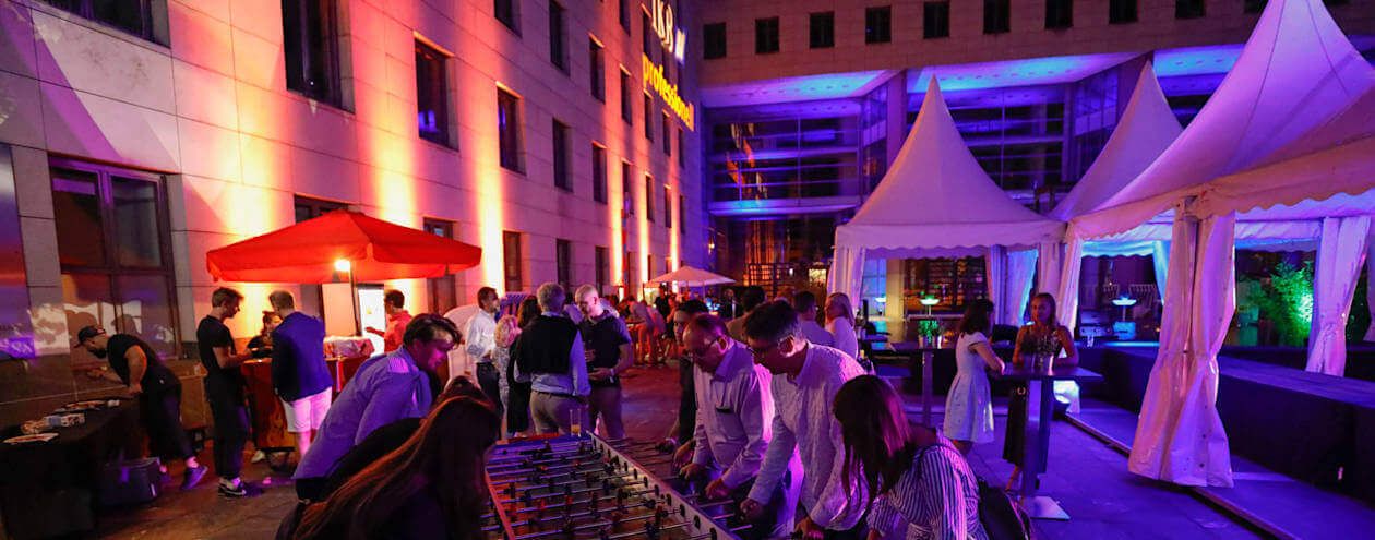 Caterig bei Firmenevent mit Zelten, Bar und Kicker bei bunter beleuchtung in der Nacht