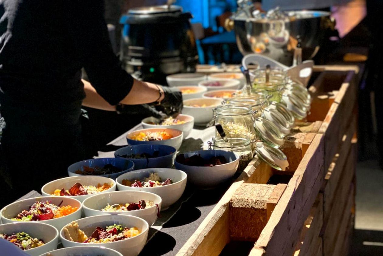Mitarbeiter bereitet Bowls für ein Catering-Buffet