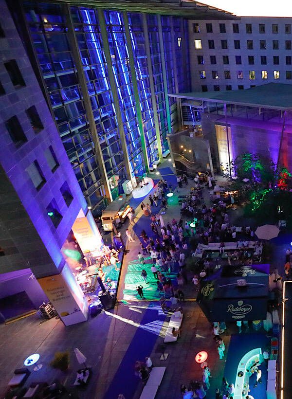 Grosses Firmenevent bei Nacht mit bunter Beleuchtung und STREET-KITCHEN Catering